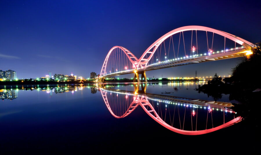 圖／新月橋點點霓虹照亮拱橋優美的弧形，倒映在河面上的景觀與夜空中的月光相互輝映。（圖／新北市政府觀光旅遊局提供）