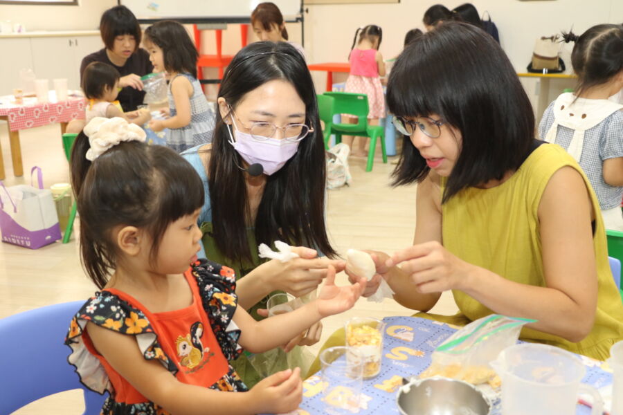 圖／小鹿老師指導親子，一層鮮奶油一層餅乾碎片。（新北市政府社會局提供）