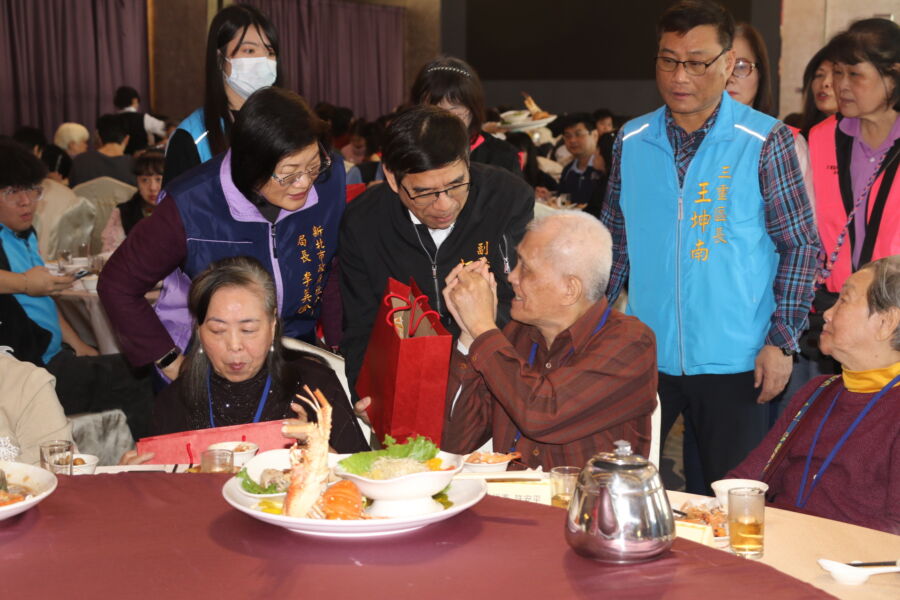 圖／新北市副秘書長柯慶忠、社會局長李美珍代表市長侯友宜致贈保溫瓶、毛帽，預祝長輩新年快樂。（新北市政府社會局提供）