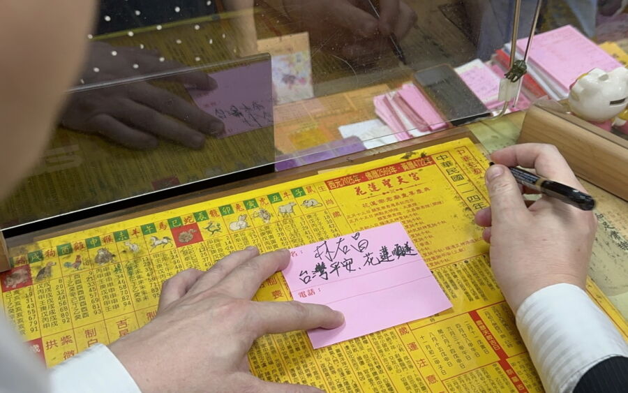 圖／民進黨秘書長林右昌特地至聖天宮點光明燈，並寫下台灣平安、花蓮順遂。（民進黨提供）