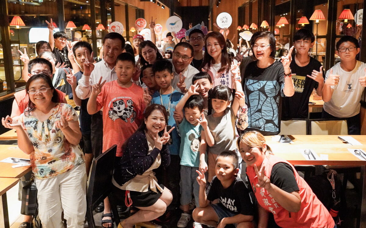 圖／饗食天堂攜手社會局舉辦公益餐會，新北市長侯友宜驚喜現身，和議員江怡臻、黃淑君及社會局長李美珍等與小衛星兒少、照顧者們合影。（新北市政府社會局提供）
