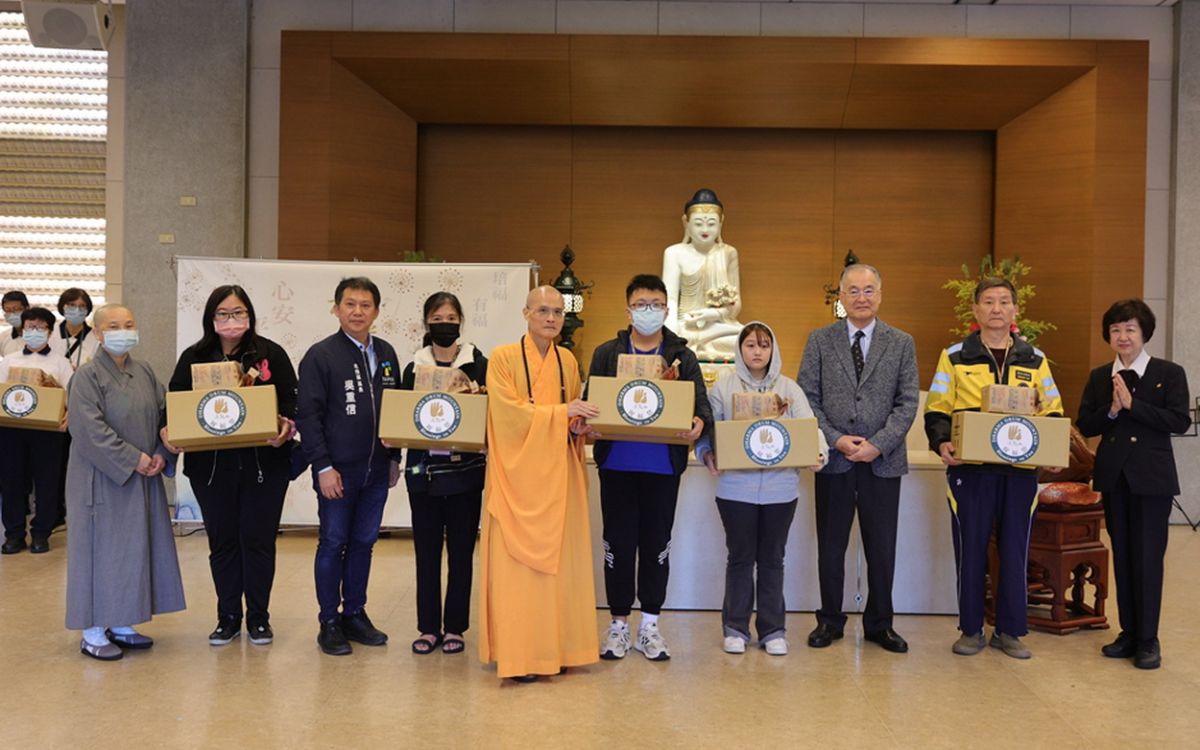 圖/方丈和尚果暉法師與多位貴賓親手將冬令物資交到每戶家庭手中,象徵佛法走入生活、溫暖人心。(法鼓山提供)