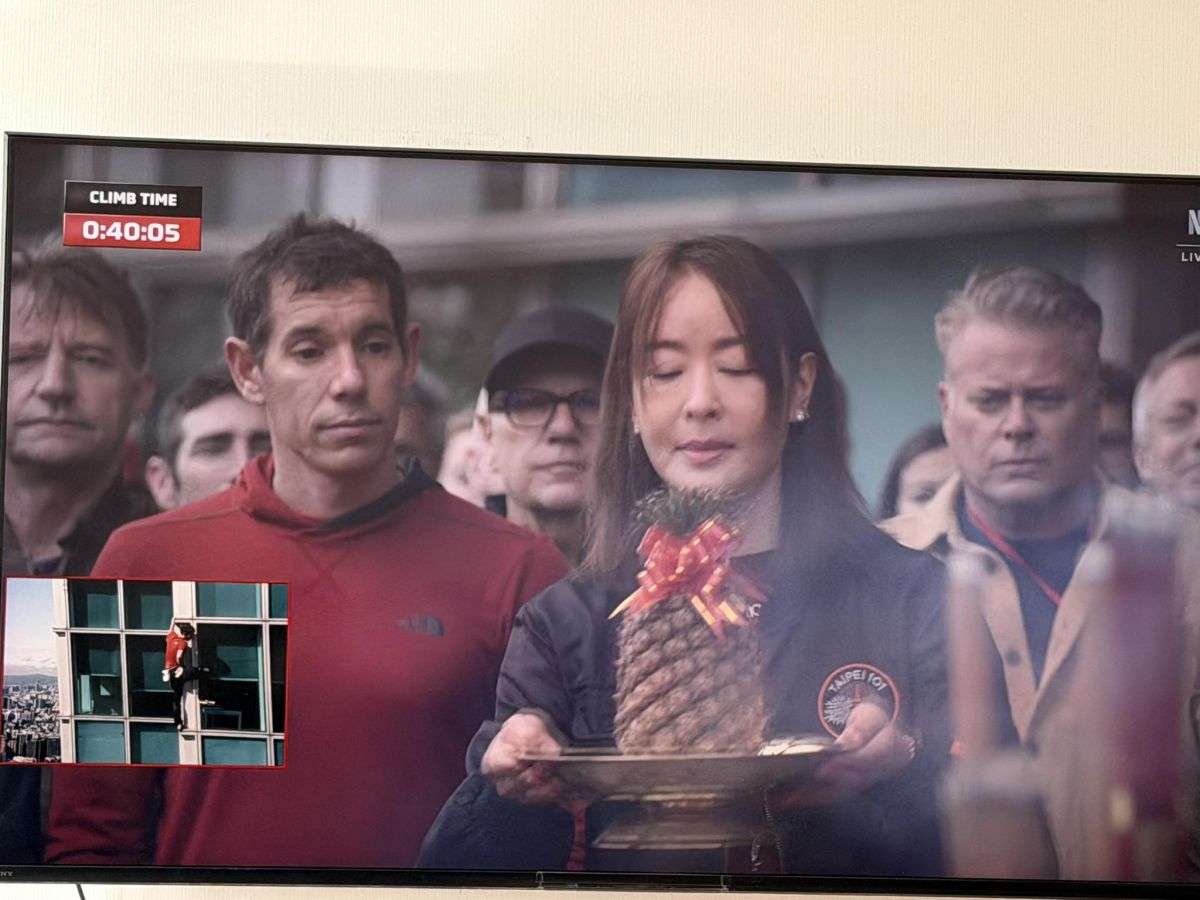 圖／賈永婕雙手捧著象徵「旺來」的鳳梨虔誠祈願，而站在一旁的霍諾德則露出略顯困惑的神情，形成強烈對比。（翻攝 杜承哲醫師臉書）