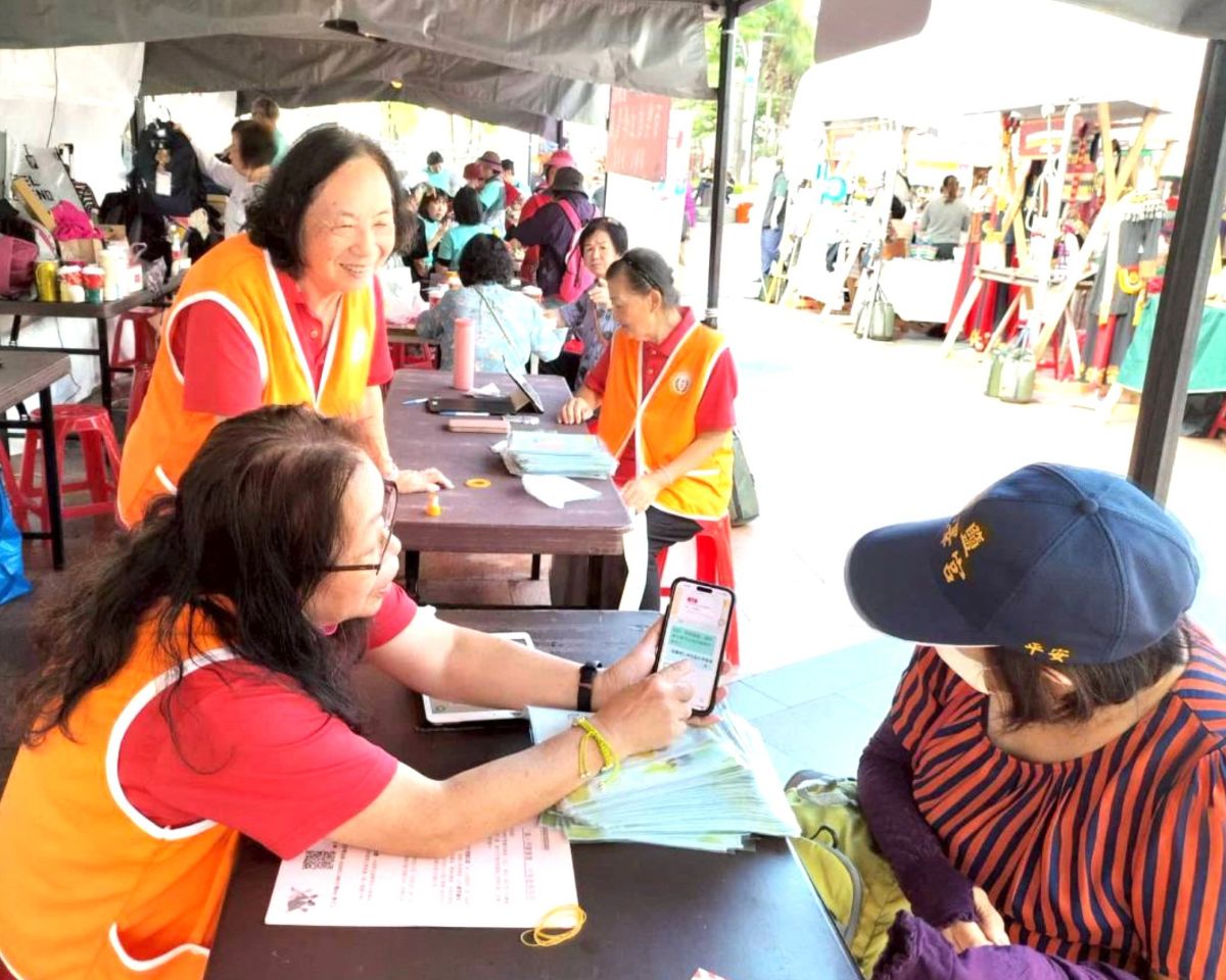 圖／民眾認真聆聽諮詢師用手機解說學習地圖網AI客服。（新北市政府教育局提供）