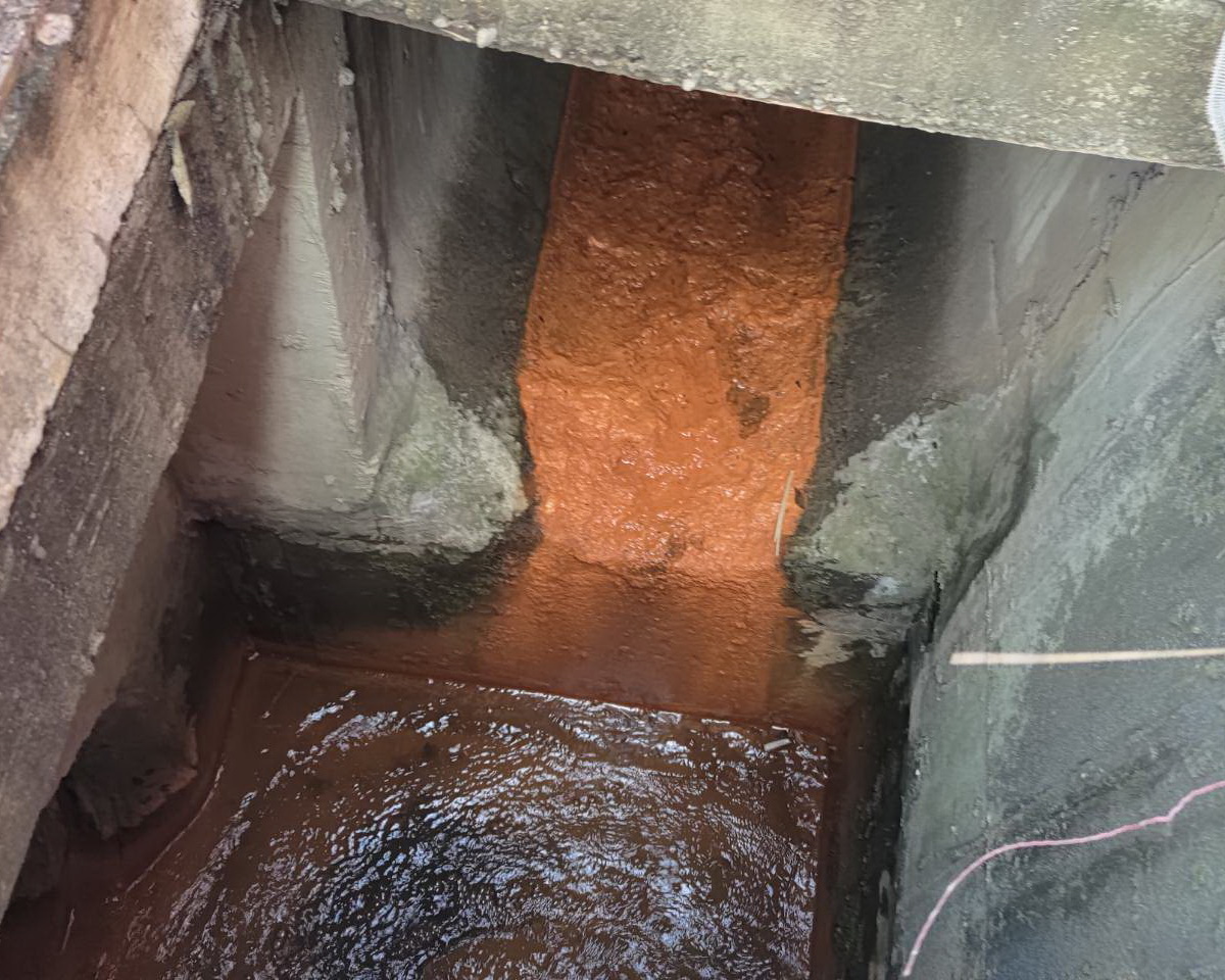 圖/稽查員與土紅色沉積之廠商確認污染範圍,並要求立即清除。(新北市政府環保局提供)