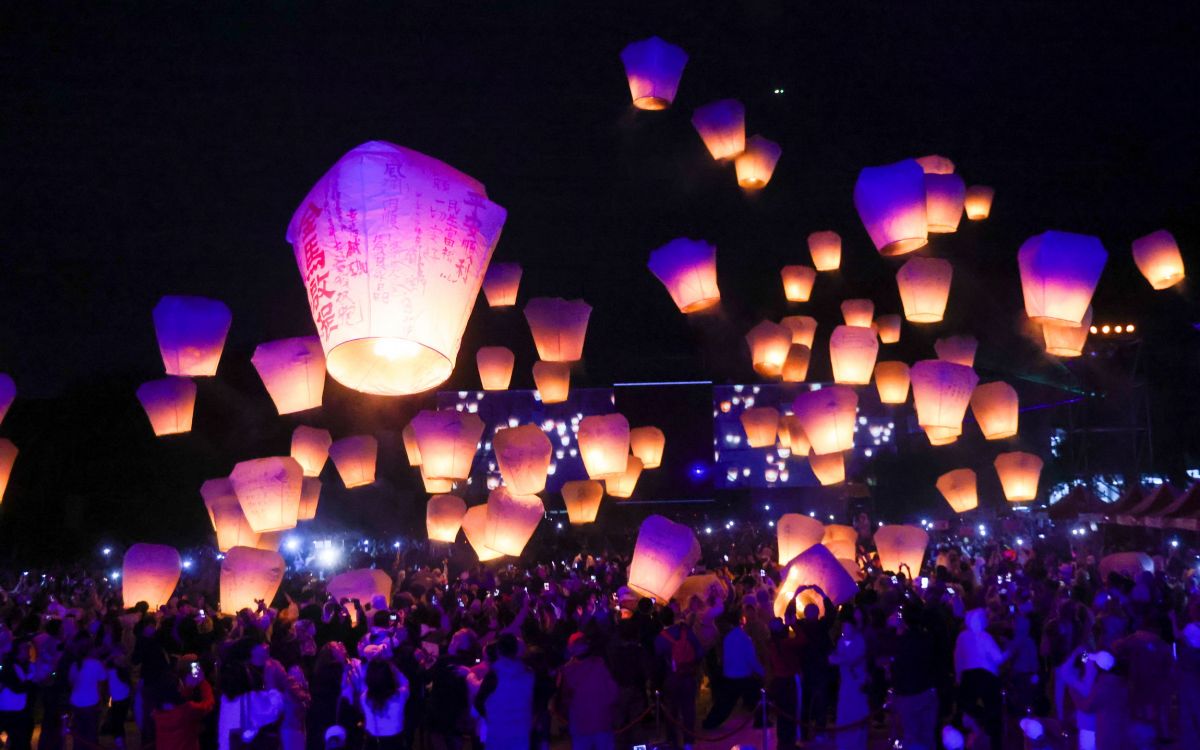 圖／百盞天燈緩緩升空，溫暖光芒與絢麗光雕交織，點亮平溪山城夜空。（新北市政府新聞局提供）