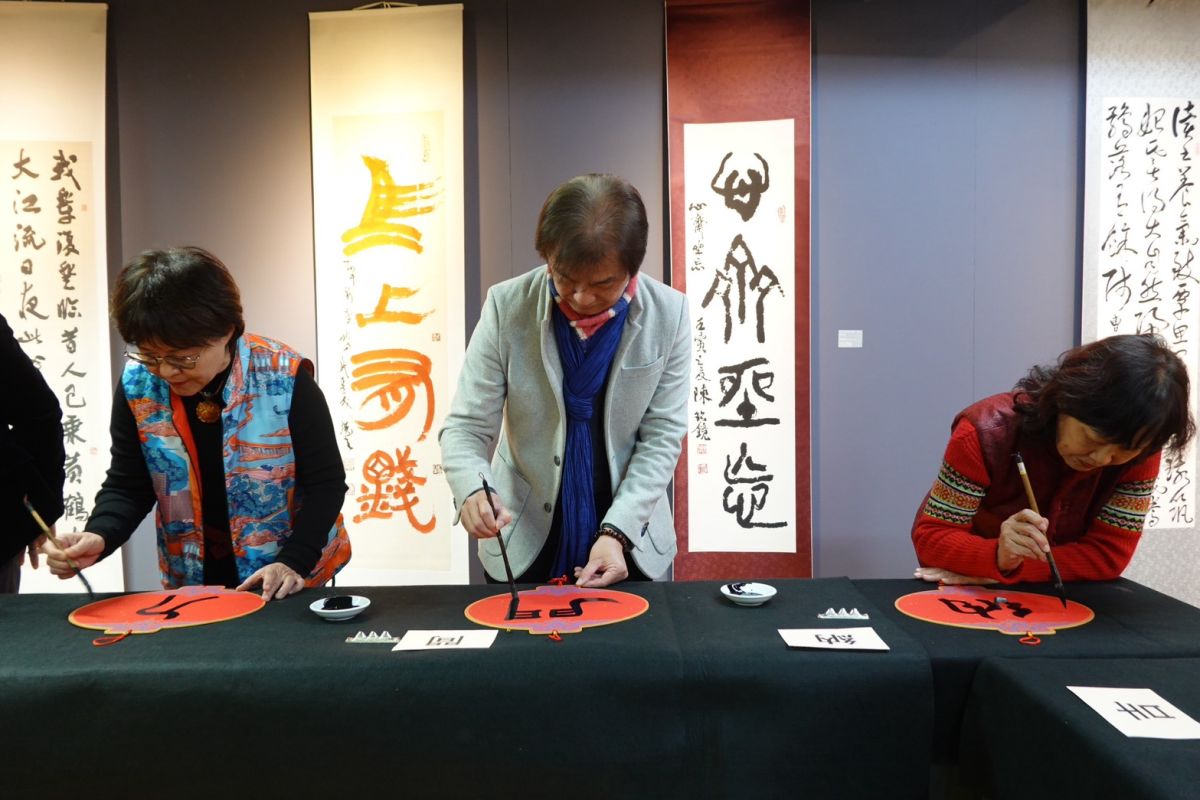  圖／華梵大學人文與藝術學院黃智陽院長（中）與其他書法家現場揮毫寫春聯。（華梵大學 提供）