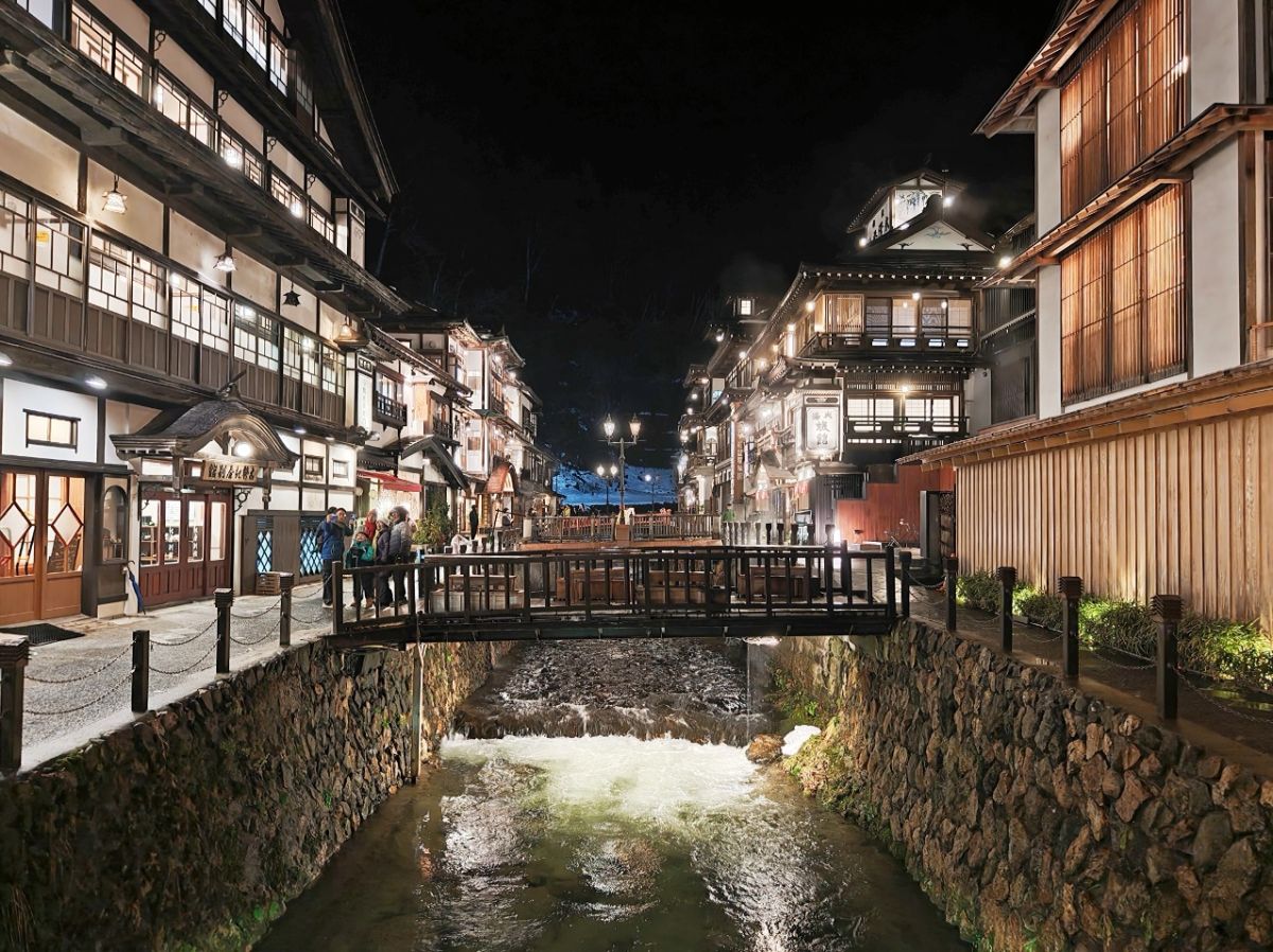 圖／銀山川兩岸的大正時代木造旅館在夜燈映照下，散發出濃厚的昭和懷舊氛圍。（日和旅行社提供）