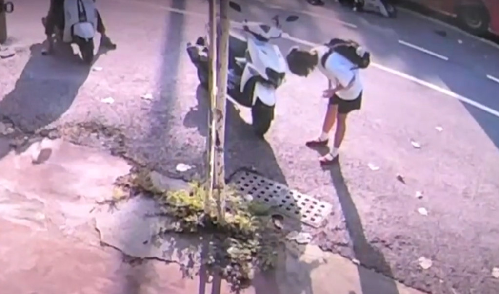 圖／現場監視器畫面流出，可見肇事的戴姓女騎士事後蹲下查看機車的車損狀況，始終未前往察看被害女警傷勢。（翻攝網路）