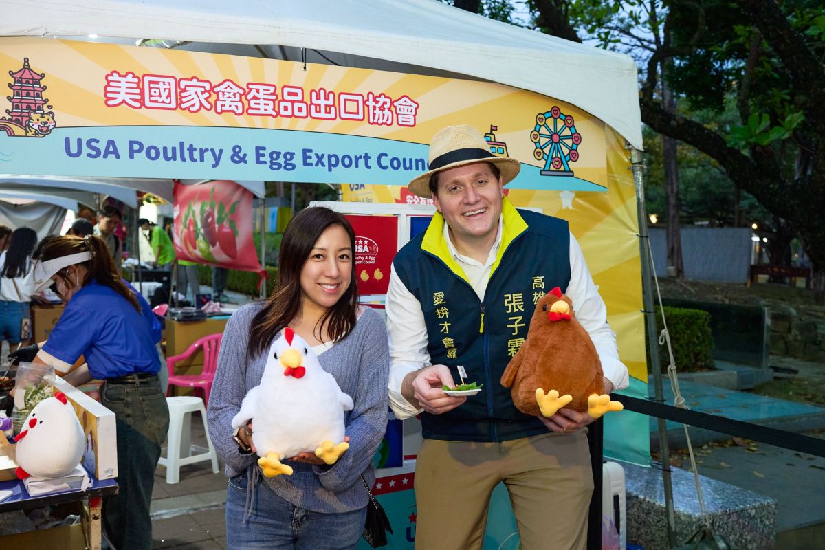圖/美國在台協會(AIT)高雄分處處長張子霖(右)與美國家禽蛋品出口協會總監江嘉詠(左)與民眾同樂,參與現場互動小遊戲、品嚐愛心雞肉小點,感受活動熱鬧氛圍。(美國家禽蛋品出口協會 提供)