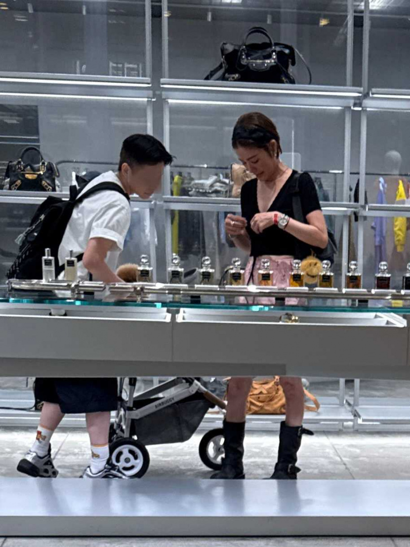圖／許路兒低頭處理衣服。（讀者提供）