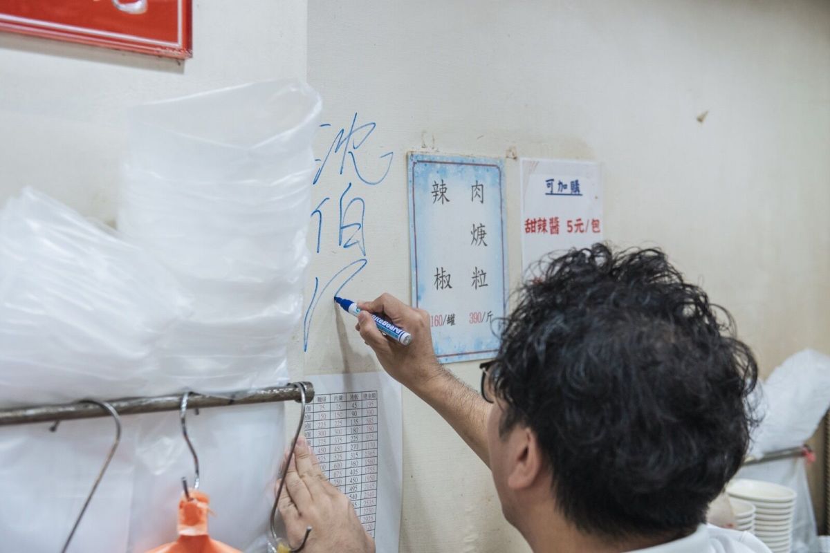 圖/沈伯洋前往饒河夜市拜票,在牆上留下簽名。(沈伯洋競選辦公室提供)