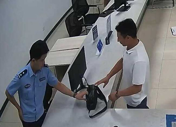 圖／潘先生將裝有現金的包包交給警方。（翻攝自杭州日報）