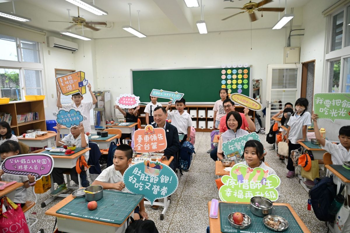 圖／副縣長王志輝與光明國小師生手持標語開心合影，歡慶臺東縣營養午餐免費補助擴大及餐費全面升級。（臺東縣政府提供）